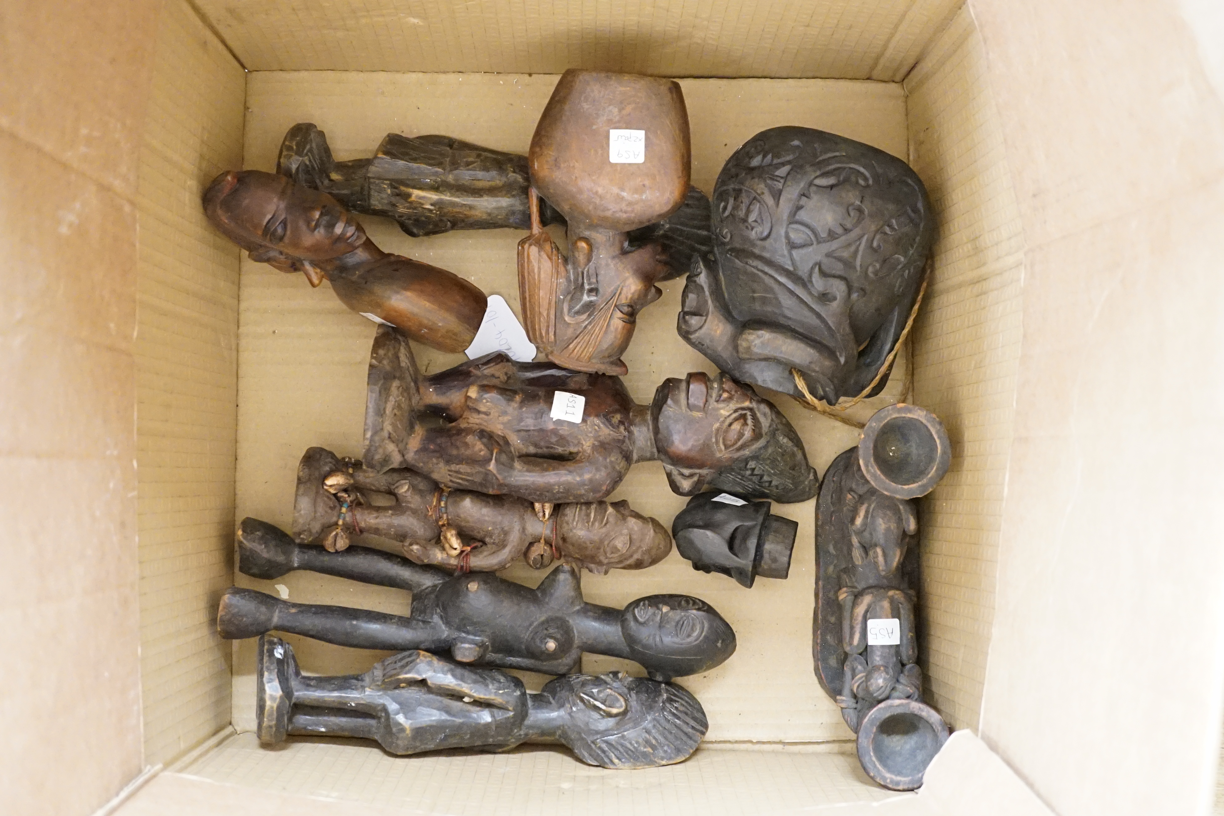 Eight Yoruba carved wood tribal figures, terracotta vessel, Ceylonese painted wood mask, East Java mask, pig mask, to African tribal masks, carved gourd vessel, four wood carvings and an instrument, largest 50cm